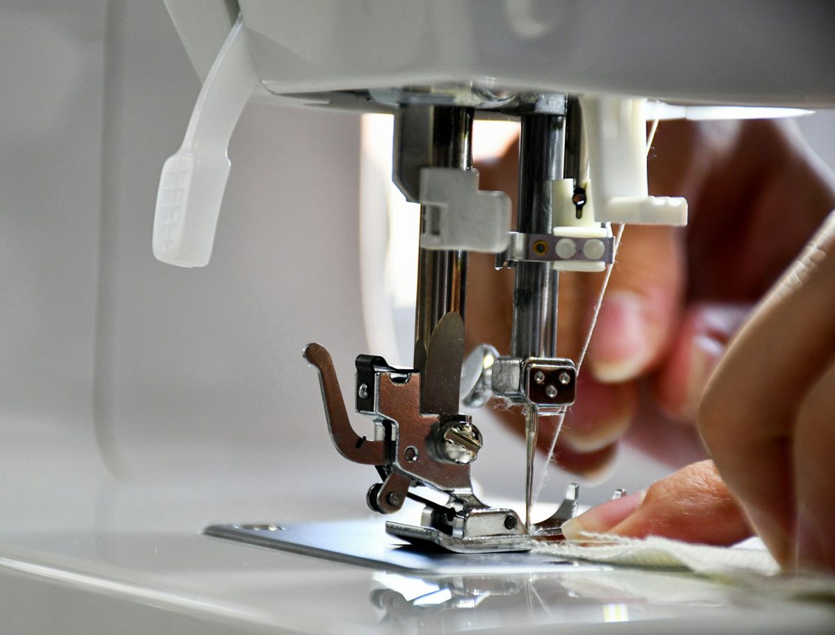 Person sewing fabric on a sewing machine