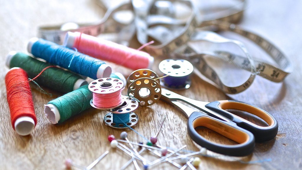 Colorful spools of thread, a measuring tape and scissors